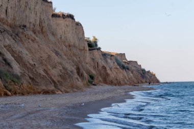 Karadeniz kıyısı, sahildeki manzara, kumlu uçurum ve güneşli yaz gününde tek bulutlu mavi gökyüzü. Sanzhiika, Odessa bölgesi, Ukrayna.