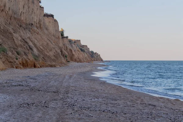 Karadeniz kıyısı, sahildeki manzara, kumlu uçurum ve güneşli yaz gününde tek bulutlu mavi gökyüzü. Sanzhiika, Odessa bölgesi, Ukrayna.
