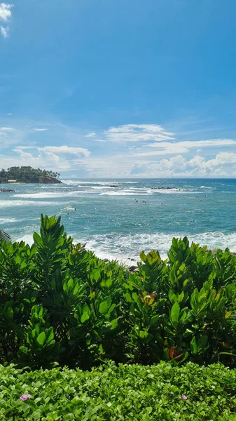 Yumuşak altın kumları ve bereketli yeşilliklerle çerçevelenmiş turkuaz suları olan güzel tropikal plajlar. Huzurlu okyanus manzarası ve canlı renkler onu tatil ve rahatlama için mükemmel bir yer yapıyor.
