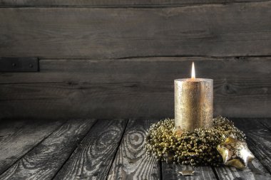 ahşap nostaljik zemin üzerine altın yanan advent mum.