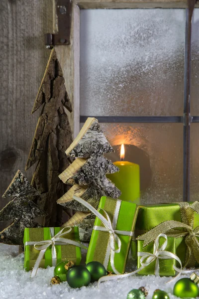Naturlig trä juldekorationer med ljus och gröna prese — Stockfoto