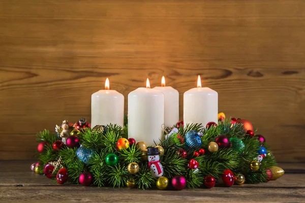 Bunter Adventskranz mit vier weißen brennenden Kerzen. — Stockfoto