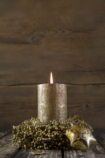 One burning golden advent candle on wooden rustic background. — Stock Photo, Image