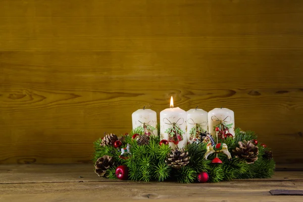 Natürlicher Adventskranz oder -krone mit einer brennenden weißen Kerze. — Stockfoto