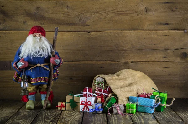 Santa claus na drewniane tła z kolorowymi prezentuje — Zdjęcie stockowe