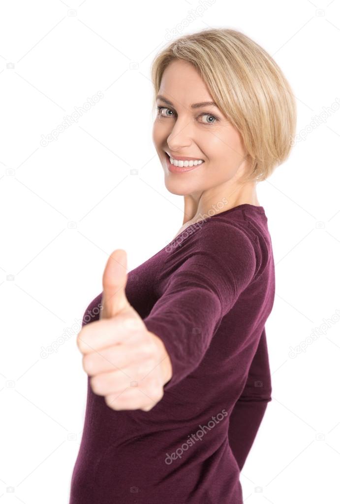 Isolated happy older blond woman with thumb up gesture.
