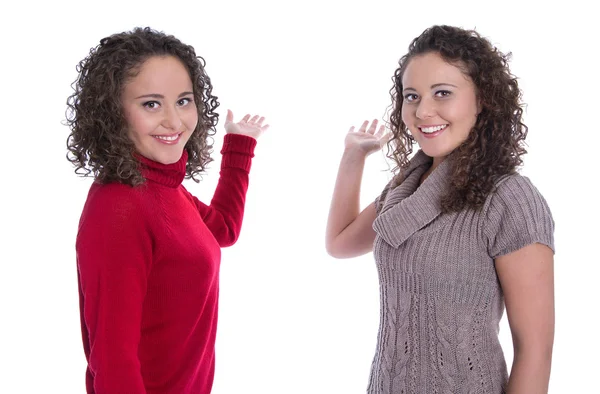 Duas meninas isoladas apresentando sobre fundo branco fazendo promo — Fotografia de Stock