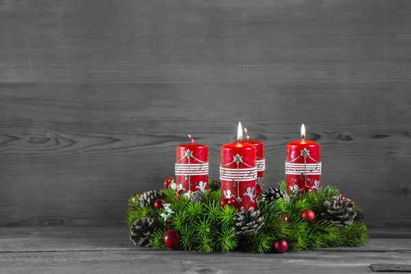 Corona de Adviento o corona con cuatro velas rojas sobre fondo de madera — Foto de Stock