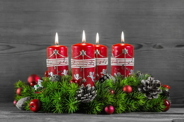 Corona de Adviento o corona con cuatro velas rojas sobre fondo de madera — Foto de Stock