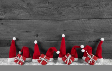ahşap gri Noel arka plan kırmızı santa şapka ve hediyeler ile.