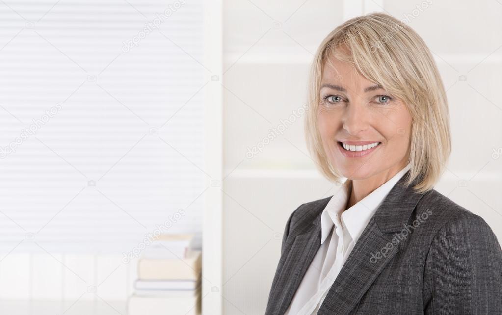 Attractive smiling middle aged businesswoman in portrait wearing