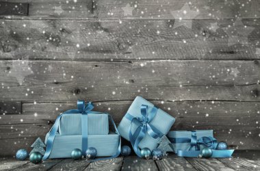 Grey wooden christmas background with a stack of presents in blu clipart