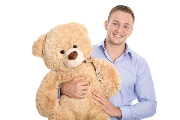 Geïsoleerd glimlachend gelukkig jonge man houden teddybeer in zijn handen — Stockfoto