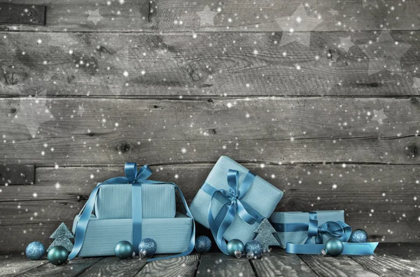 Sfondo di Natale in legno grigio con una pila di regali in blu Foto Stock