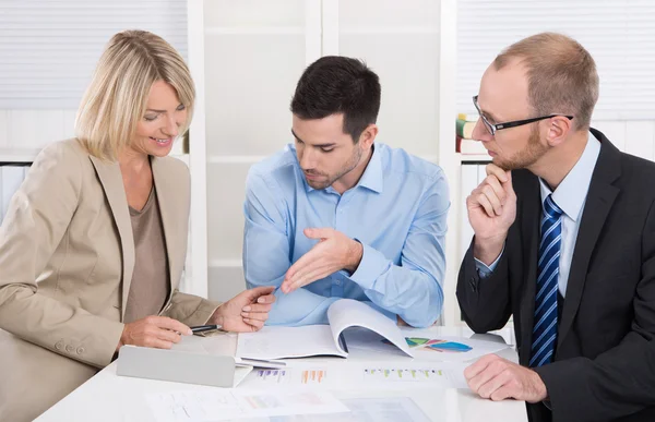 Equipo de negocios exitoso sentado alrededor de una mesa en una reunión . —  Fotos de Stock