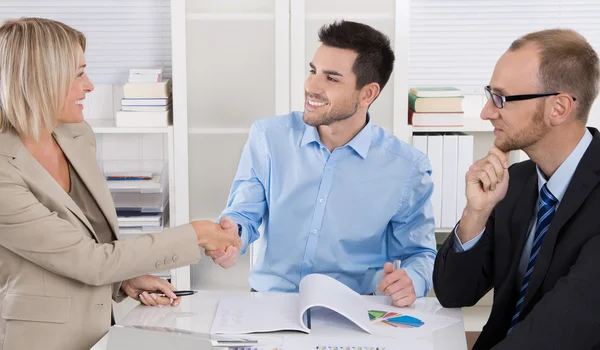 Equipo de negocios exitoso sentado alrededor de una mesa en una reunión . — Foto de Stock