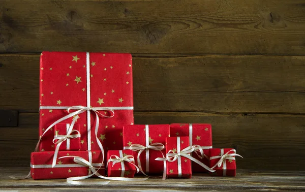 Rote Weihnachtsgeschenke auf altem hölzernen braunen Hintergrund. — Stockfoto