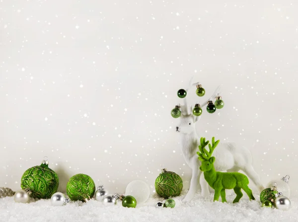Weihnachtsdekoration: grüne Rentiere auf weißem Holzgrund. — Stockfoto