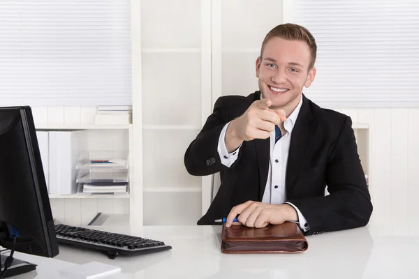 Glücklicher junger Geschäftsmann sitzt in seinem Büro und gibt Ratschläge für cu — Stockfoto