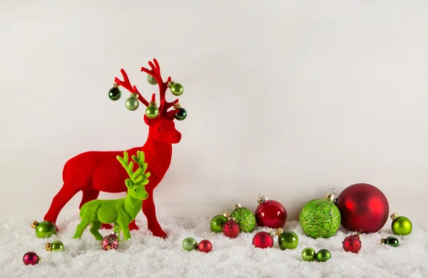 Red and green christmas decoration with reindeer and snow for a — Stock Photo, Image