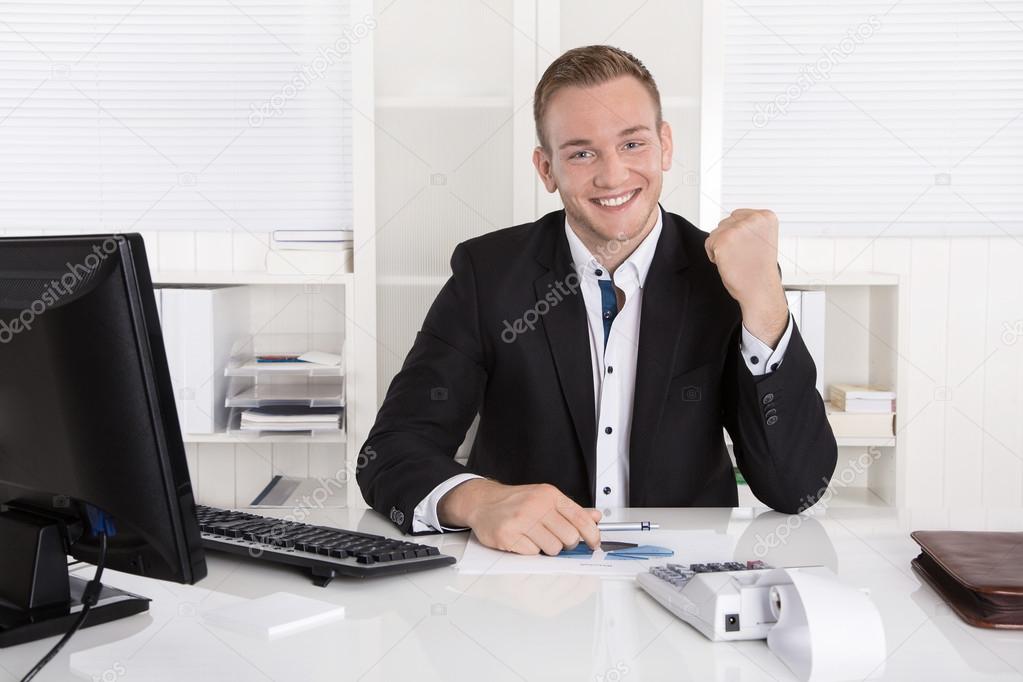 Successful young businessman proud of his success and cheering i