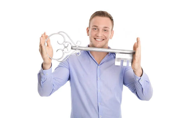 Proud isolated business man holding a key for a new house in his — Stock Photo, Image