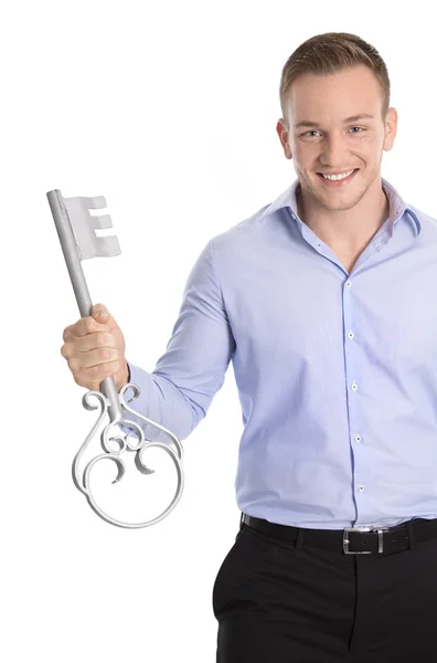 Orgulloso hombre de negocios aislado sosteniendo una llave para una nueva casa en su — Foto de Stock