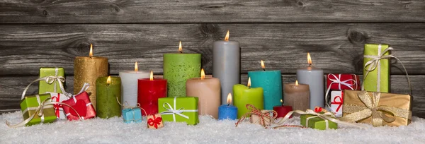 Colorida decoración navideña con regalos y velas encendidas . —  Fotos de Stock