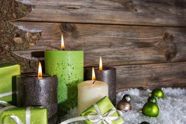 Vier brandende appel Groene Kerst kaarsen op houten achtergrond. — Stockfoto