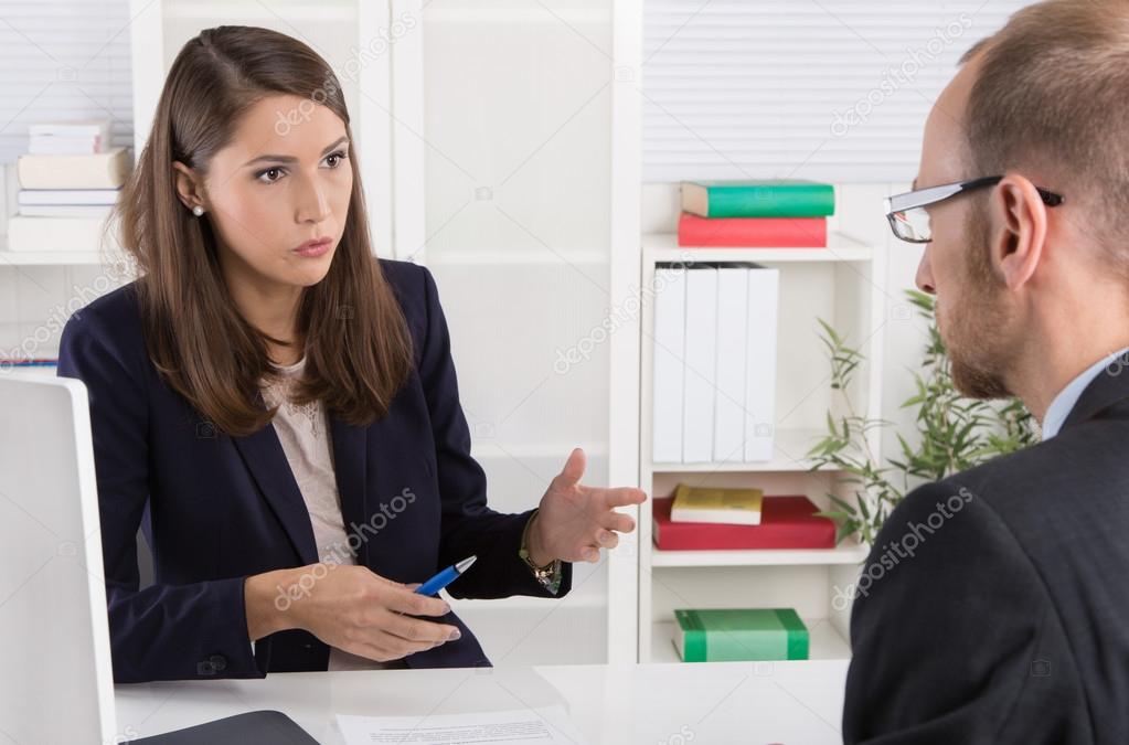 Customer and female financial agent in a discussion at desk.