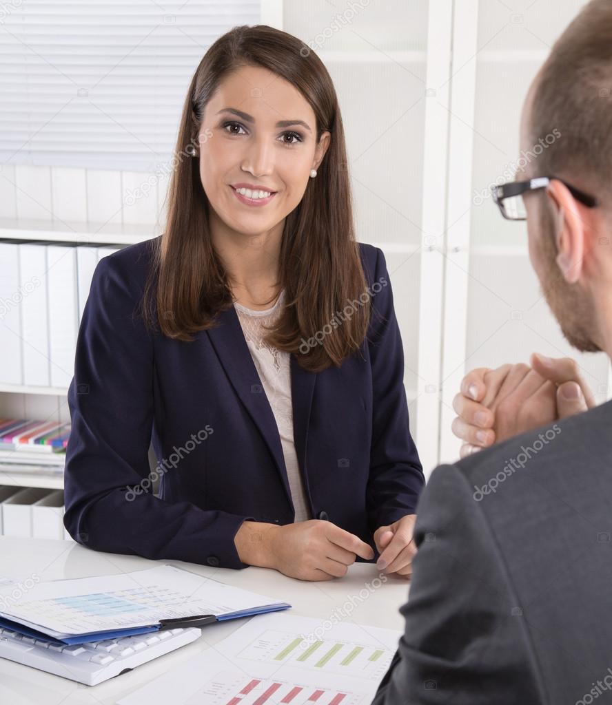 Customer and female financial agent in a discussion at desk.