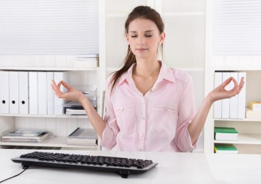 Genç iş kadını ofiste bir mola verme ve meditasyon.