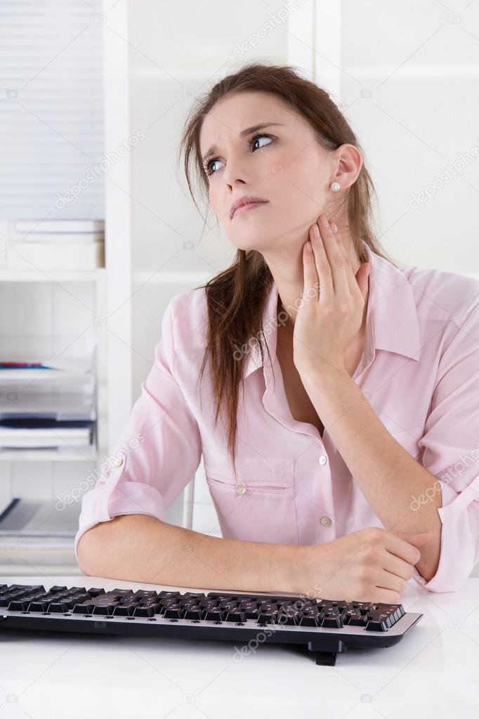 Young woman sitting at desk having pains in the neck or swollen 