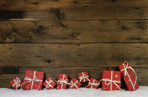 Sfondo rustico in legno con regali di Natale rossi . Immagine Stock