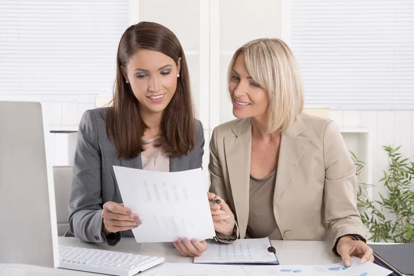 Vrouwelijke senior en junior managers zitten aan een bureau werken togeth — Stockfoto