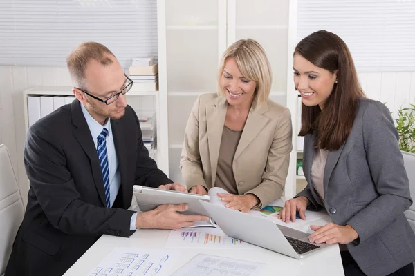 Equipe de três empresários sentados juntos na mesa em um encontro — Fotografia de Stock