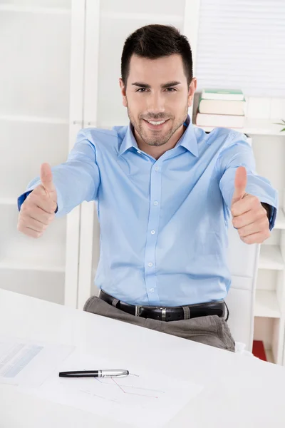 Tummen upp: glad stolt affärsman sitter i hans kontor bär — Stockfoto