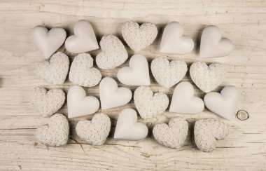 Beige or old white hearts on wooden shabby chic background.