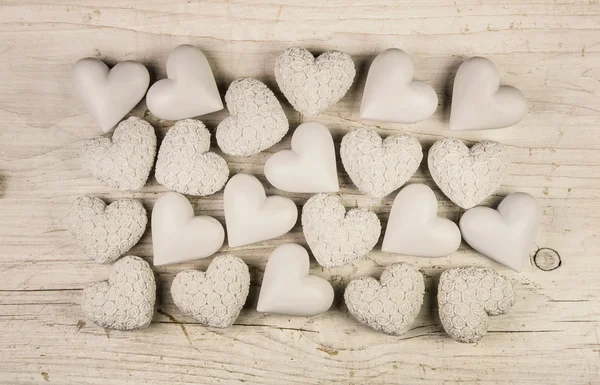 Beige or old white hearts on wooden shabby chic background. — Stock Photo, Image
