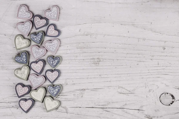 Shabby chic grey wooden background with a collection of hearts o — Stock Photo, Image