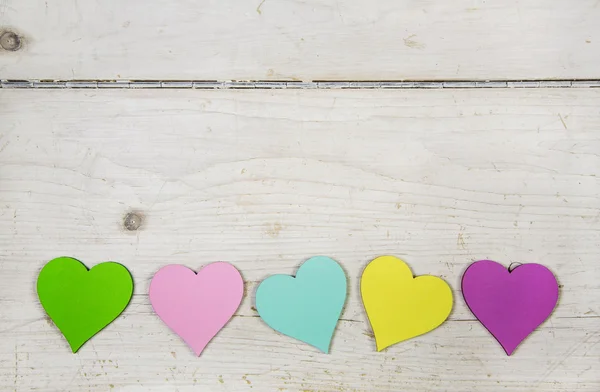 Colorful hearts  on old wooden white shabby chic background. — Stock Photo, Image