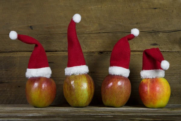 재미 있은 크리스마스 인사말 카드 애플에 4 개의 빨간 산타 모자 — 스톡 사진