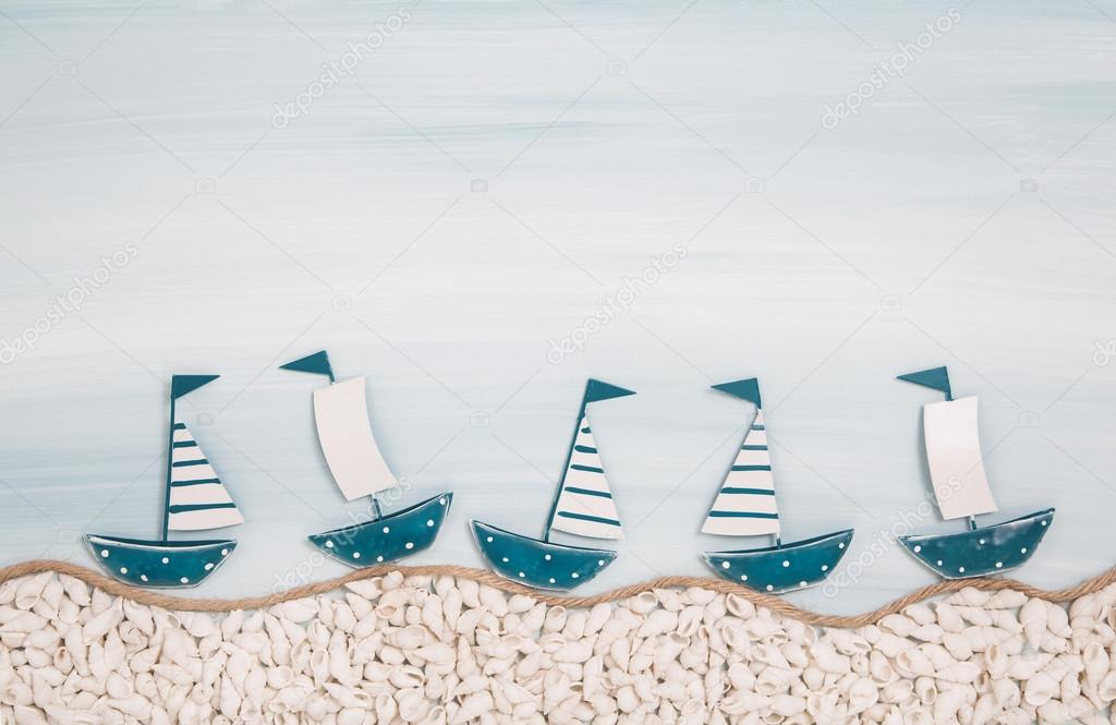 Five metal handmade sailboats on a blue ocean background for sum
