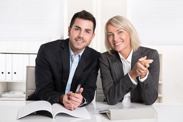 Zufriedene männliche und weibliche Geschäftsleute sitzen im Büro. Erfolg — Stockfoto