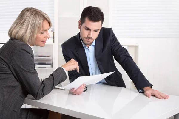 Trabajo en equipo exitoso: hombre de negocios y mujer sentados en el escritorio talki — Foto de Stock