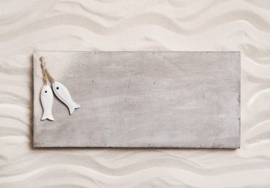 Wooden background with sand and two fishes on an sign like a mes clipart