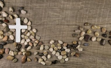 Cross of stones on wooden background for condolence or mourning  clipart