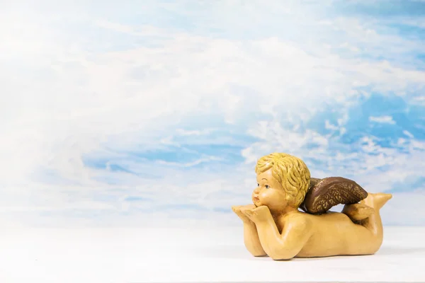 Figurine d'ange soufflant sur un fond de paradis . — Photo