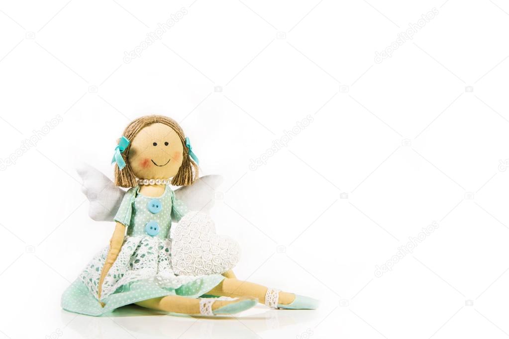 Guardian angel: isolated handmade doll with a white heart in her