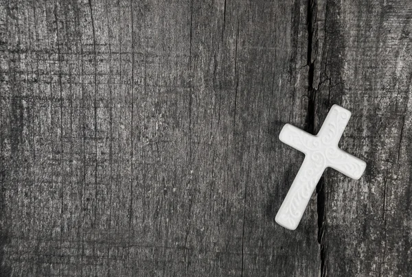 White cross on a grey wooden background. — Stock Photo, Image